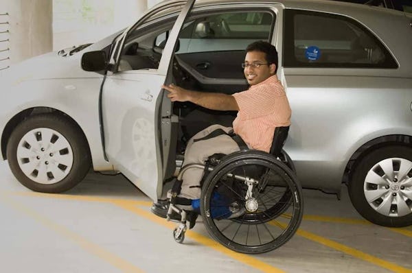 Pessoa com cadeira de rodas entrando em carro