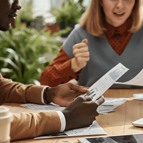 Homem e mulher segurando papeis e discutindo
