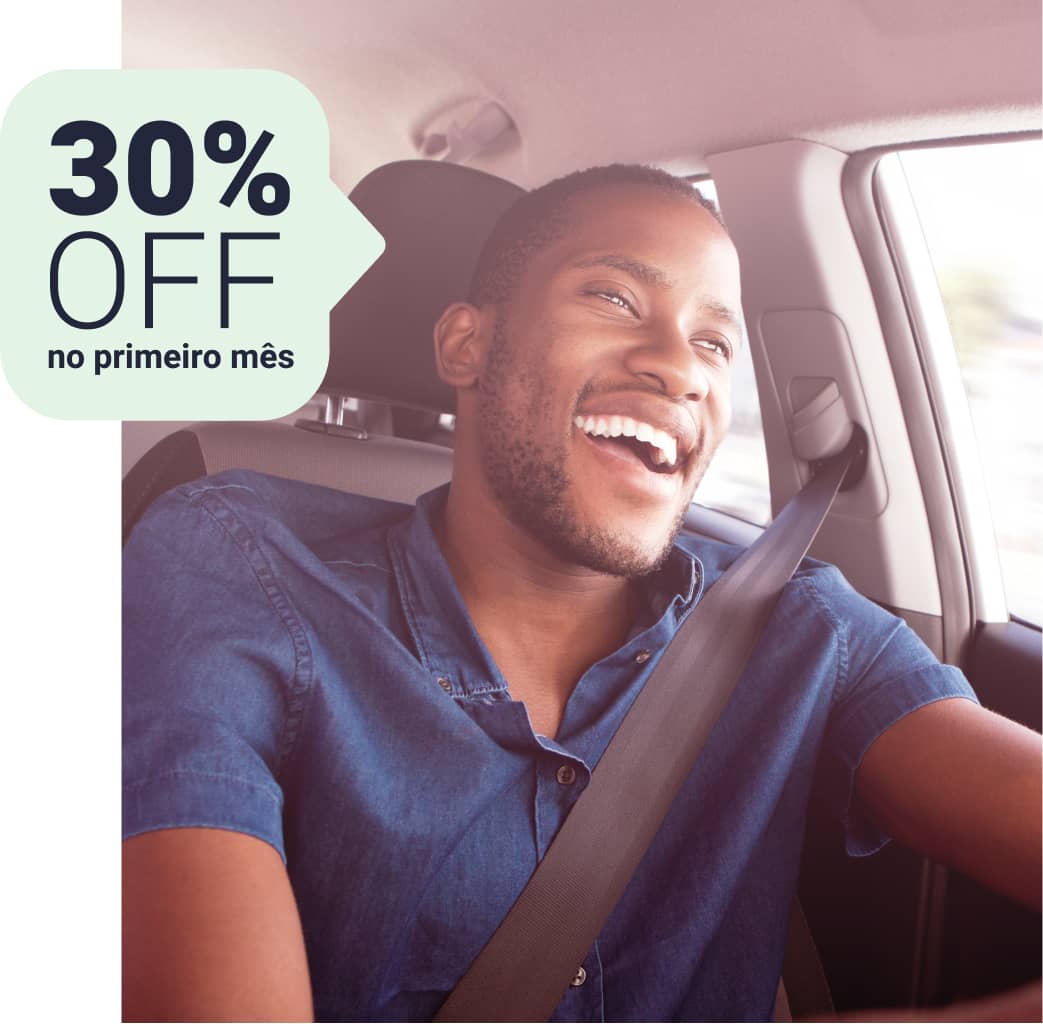 Imagem frontal de um homem dirigindo um carro olhando para a estrada e sorrindo, balão verde com desconto 30% OFF no primeiro mês.